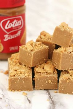 several pieces of peanut butter fudge next to a jar of peanut butter