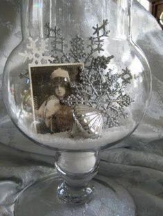 a glass vase filled with snow and pictures