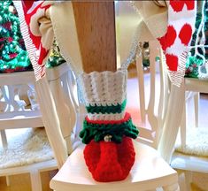 a crocheted christmas stocking sitting on top of a white chair