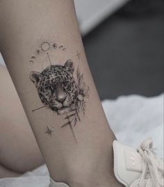 a woman's foot with a tattoo on it that has a leopard head and stars