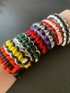 a person's arm with several different colored bracelets on it