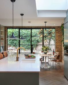 an open kitchen and dining area with skylights in the ceiling, along with large windows