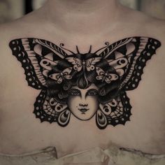 a woman's chest with a butterfly tattoo on top of her head and eyes