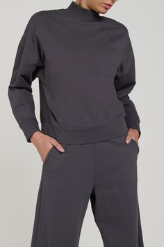 The Zen Mock Neck Sweatshirt, part of a matching set. Made from 95% organic cotton and 5% spandex. The organic French Terry fabric is not only comfortable, but also environmentally friendly. The crewneck design gives a timeless and classic. This sweater is perfect to match with the Bio Terry Pants or Bio Terry Joggers. Available in Carbon and Black. Product Features: FIT: The Zen Mock Neck Sweatshirt is soft, comfortable, with a relaxed fit. Features: Super soft organic terry cotton fabric, crew Cozy Fit Solid Cotton Tops, Relaxed Fit Crew Neck Top With Ribbed Neckline, Cozy Fit Basic Top For Loungewear, Solid Cotton Top With Ribbed Collar, Cotton Tops With Ribbed Collar, Cotton Top With Ribbed Collar, Fall Solid Tops With Ribbed Waistband, Everyday Cotton Athleisure Sweater, Solid Tops With Ribbed Waistband For Fall