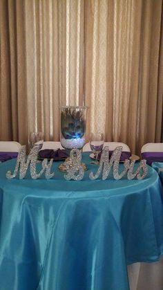 the table is set up with blue cloths and silver letters that read mr and mrs