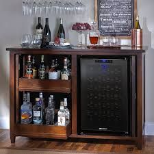 a wooden bar with wine glasses and liquor bottles on the top shelf next to it