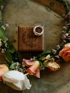 a wooden ring sits on top of some flowers