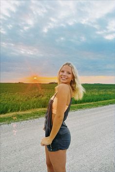 a woman standing in the middle of a road