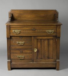 an old wooden desk with drawers and brass handles