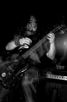 a man with long hair playing a guitar