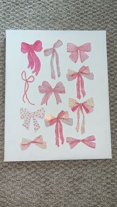 some pink and white bows sitting on top of a piece of paper