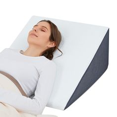 a woman laying on top of a pillow in the shape of a reclining position