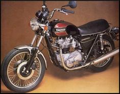 a black and red motorcycle parked in front of a brown background