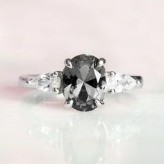 a black and white diamond ring with three stones