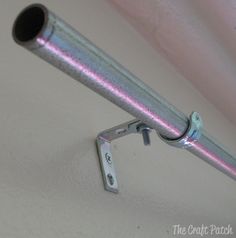 a close up of a metal object on a white surface with pink and silver paint