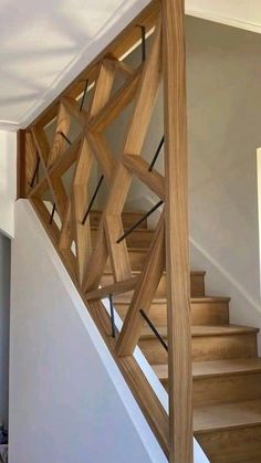 a wooden stair case in a house with white walls