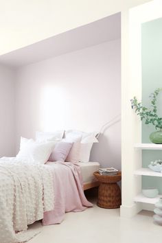 a bedroom with pink walls and white furniture