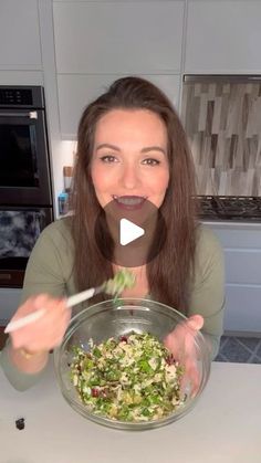 a woman is eating salad in the kitchen