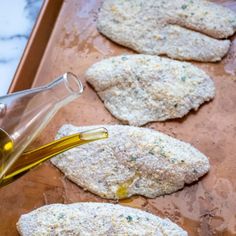 raw fish fillets on a baking sheet with olive oil