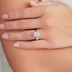 a woman's hand with a diamond ring on it