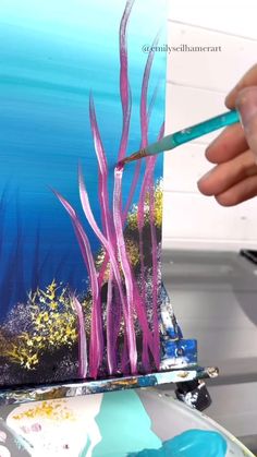 someone is painting an underwater scene with blue and purple paint