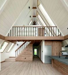 an open floor plan with wood floors and white walls, along with stairs leading up to the second floor