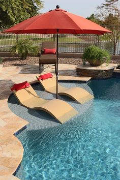 a pool with lounge chairs and an umbrella