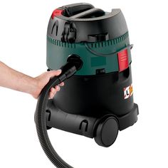 a person is using a vacuum cleaner to clean the floor with their hand on it