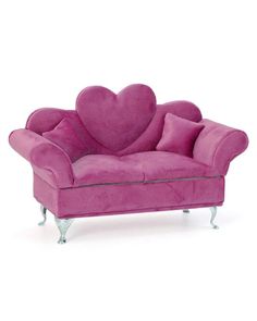 a pink couch with a heart shaped pillow on it's back and legs, sitting in front of a white background