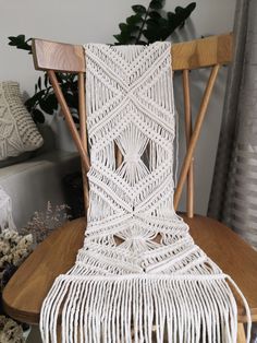 a white chair sitting on top of a wooden table next to a potted plant