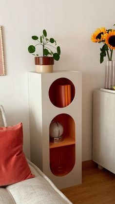 a living room with a couch and two vases on top of the same shelf