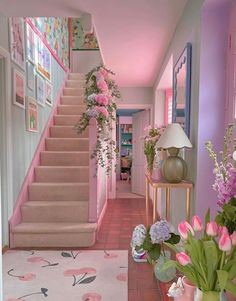 the hallway is decorated in pink and white with flowers on the floor, along with potted plants