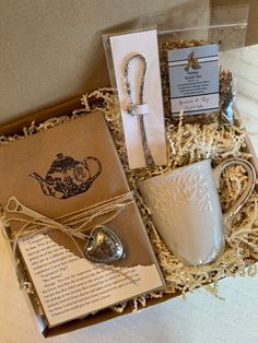 a gift box containing a mug, spoon and tea bag with an open note card