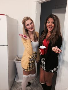 two young women standing next to each other in front of a white refrigerator freezer