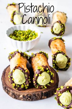 chocolate covered pastries with green sprinkles next to a bowl of pistachio