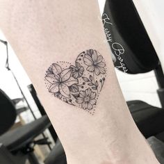 a heart shaped tattoo with flowers on it