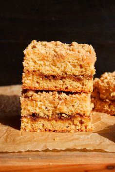 three pieces of cake sitting on top of a wooden cutting board