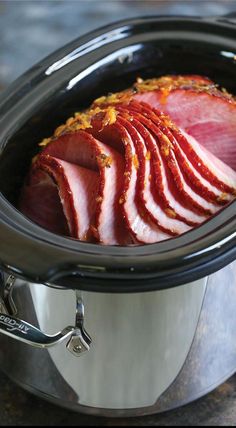 sliced ham in a slow cooker ready to be cooked