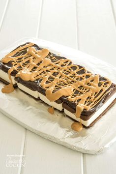 a piece of cake sitting on top of a plastic wrapper covered in frosting