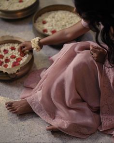 a woman sitting on the floor in front of some pies