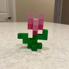 a pink and green blocky toy sitting on top of a white marble countertop