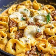 a close up of a plate of pasta with meat and cheese