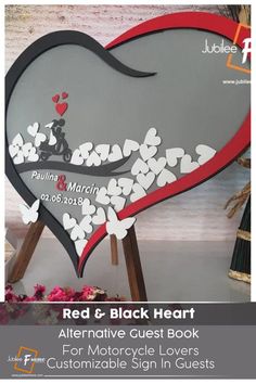 a heart shaped sign with flowers and hearts on the side, in red and black