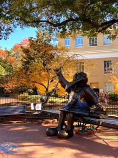 a statue of a man sitting on top of a bench