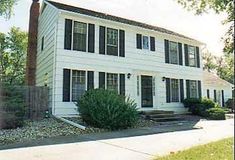 a white two story house with black shutters