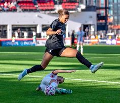 two women are playing soccer on the field