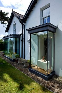 an outside view of a white house with glass walls