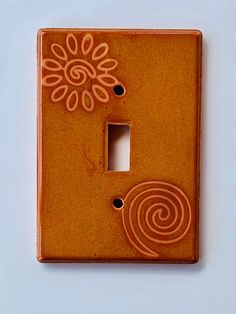 a light switch cover with an orange flower design