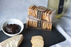 crackers, jam and cheese on a black slate board