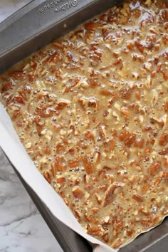 an uncooked casserole in a pan on a marble counter top,